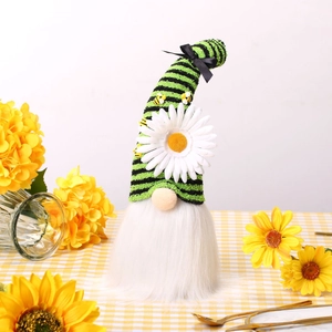 Gnomo festivo in maglia con girasole e margherite su un tavolo primaverile luminoso