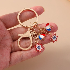 Detailed close-up of golden keychain with red blue enamel umbrella and star pendants
