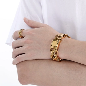 Close-up of a gold-plated stainless steel hollow X-ring and chunky chain bracelet