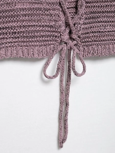 Detailed close-up of pink knit top featuring thick texture and drawstring tie detail