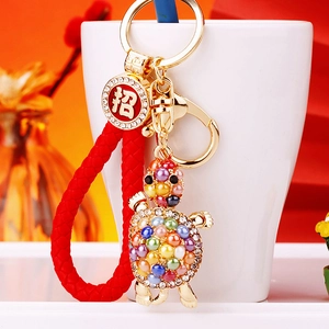 Detail of colorful turtle keychain with rhinestones and a lucky red cord handle