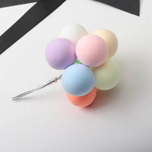 Macro shot of colorful clay balloon cake toppers in pastel pink, blue and yellow
