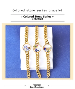 Close-up of golden bracelets with colorful crystal pendants and evil eye charms