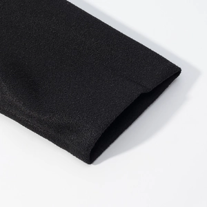 Close-up of the black high-density knit fabric texture and cuff detail of the jacket