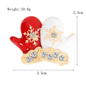 Detailed view of red and white enamel Christmas glove brooch with crystal accents