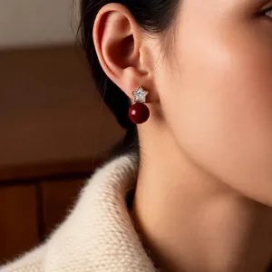 18K gold plated star earrings with red pearl on model in a retro minimalist style