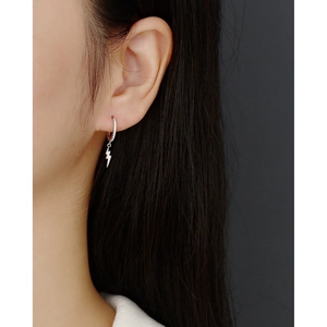 Close-up of S925 silver lightning bolt drop earrings with zircon on model's ear