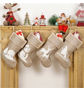 Close-up of four linen Christmas stockings with Merry Christmas print and festive patterns