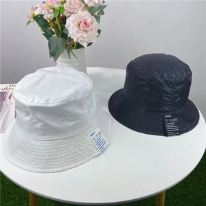Detailed view of black and white bucket hats with stylish MERCU side label decoration