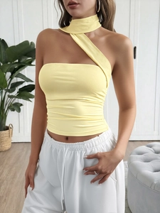 Detail view of the yellow one-shoulder halter crop top featuring pleated waist design