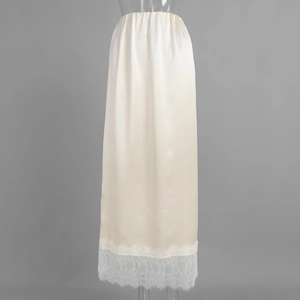 Close-up of elegant cream satin skirt featuring delicate white eyelash lace hem details
