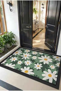 Detailed view of a green daisy pattern doormat at a bright home entrance with black doors