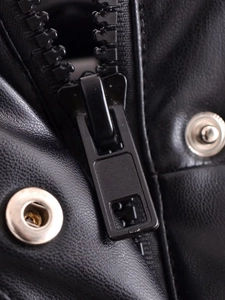 Detailaufnahme des schwarzen Lederreißverschlusses und silbernen Metalldruckknopfs