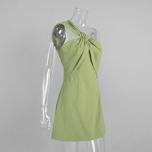 Close-up of light green mini dress featuring a one-shoulder neckline and pleated texture