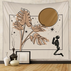 Detail of bohemian tapestry featuring dark skull art with monstera leaves and moon