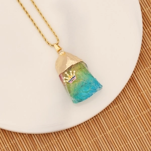 Detailed macro view of a rainbow crystal stone pendant featuring a gold crown and twisted chain