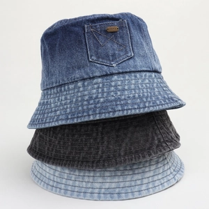 Détail de bobs en jean empilés avec poche décorative et étiquette métallique JHMY