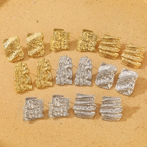 Detail of hammered irregular geometric square earrings in gold and silver stainless steel