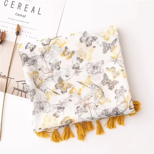 Detail of yellow butterfly print on white linen feel scarf with bright yellow tassels