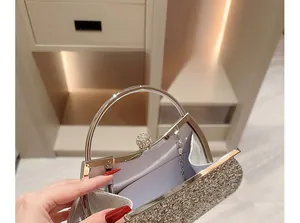 Detail of champagne gold sequined clutch with rhinestone clasp and chain strap