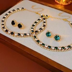 Detail of gold crystal necklace and square earring sets with green and clear stones