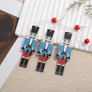 Three nutcracker wood ornaments with blue and red details on a natural background