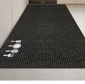 Detail of non-slip kitchen mat with striped texture and white cutlery icon on black fabric