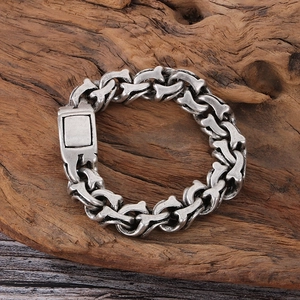 Nahaufnahme eines Vintage-Silberarmbandes mit Knochengliedern auf rustikalem Holz