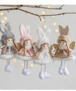 Detail of four colorful plush angel dolls with glitter wings hanging on branches