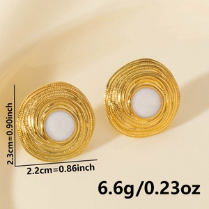 Macro view of geometric gold earrings with white stone and spiral texture details
