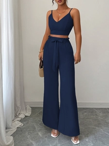Dettaglio del top con scollo a V blu scuro e dei pantaloni a vita alta con cintura