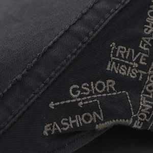 Close-up of black cotton cap with beige fashion embroidery and detailed stitching