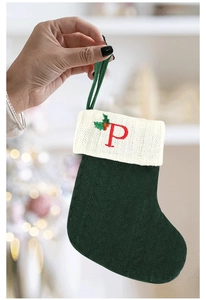 Gros plan de la chaussette de Noël tricotée verte avec revers et broderie de la lettre P