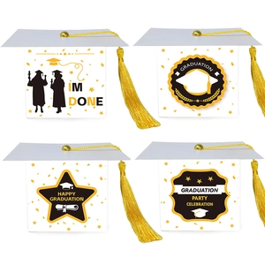 Detail of four graduation cap favor boxes with gold tassels and congratulatory patterns
