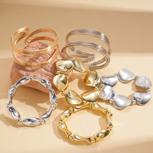 Three-piece set of geometric twisted layered open bangles in gold and silver finish