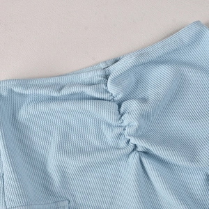 Close-up of light blue waffle knit fabric showing detailed ruching and soft texture