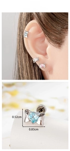 Macro detail of screw-back bow earrings with heart zircon stones and size measurements