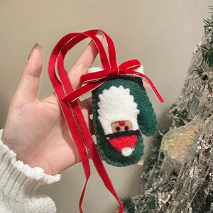 Close-up of a festive Christmas glove pendant with velvet ribbon and Santa Claus motif