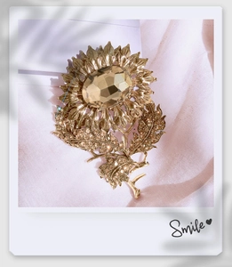 Detail of luxury sunflower brooch with amber crystal and rhinestones on satin