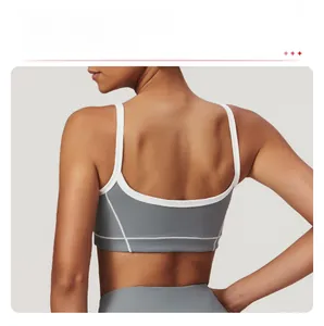 Détail du dos d'une brassière de sport gris foncé avec coupe en U et passepoil blanc contrasté