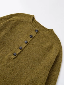 Detail of army green knit sweater showing round neck with five black buttons and wool texture