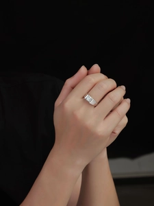 Close-up of a silver moissanite ring with a large round diamond on a hand