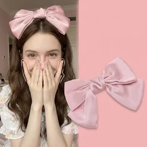 Pink satin oversized bow hair clip as worn by celebrities for a sweet elegant hairstyle