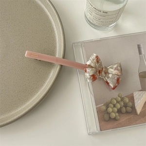 Close-up of pink acetate hair clip with marble bow and France Handmade engraving
