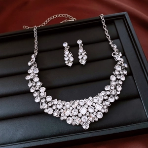 Macro shot of silver diamond necklace and earrings set in a black velvet jewelry box