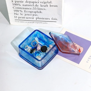 Detalle de caja de almacenamiento DIY de resina epoxi con tapa y anillos de plata
