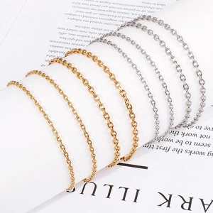 Minimalist 18k gold and silver titanium steel chain necklace set on open book