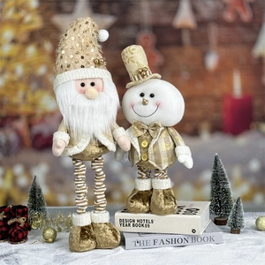 Detail of plush Santa and snowman dolls with gold sequins on decorative book