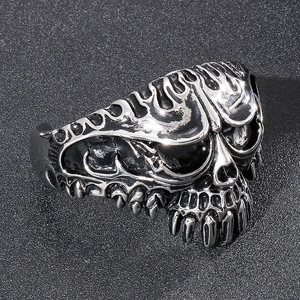 Detailed view of punk style stainless steel skull ring with vintage flame engraving