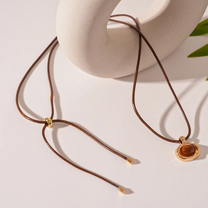 Detail of adjustable long sweater necklace featuring an oval resin amber pendant